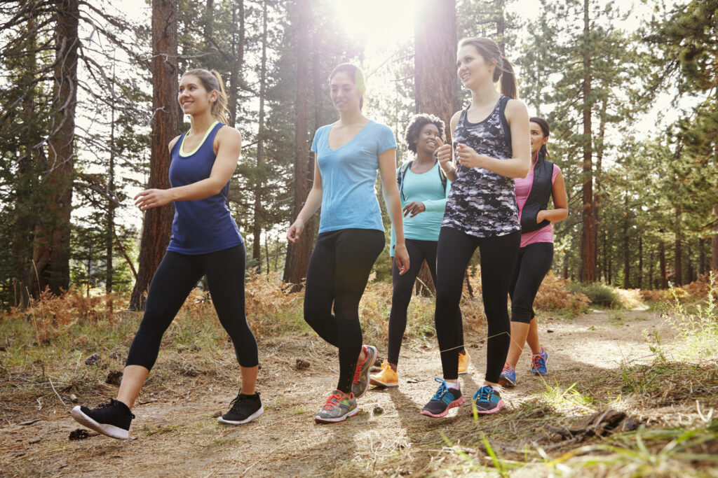 Group of women runners walking in a forest, close up